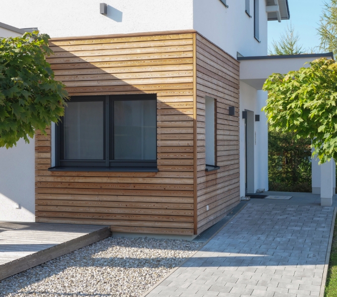 Timber-clad extension on a white rendered house